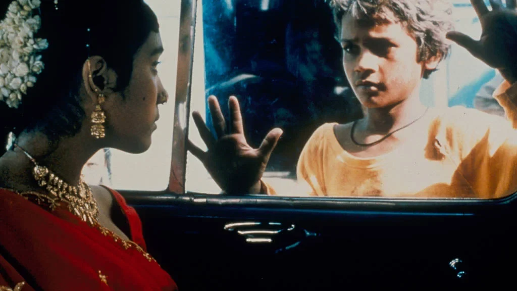 Eine Wissenschaftlerin und ein Wissenschaftler arbeiten hinter einer Glasfassade und mischen Chemikalien mit Großgeräten.