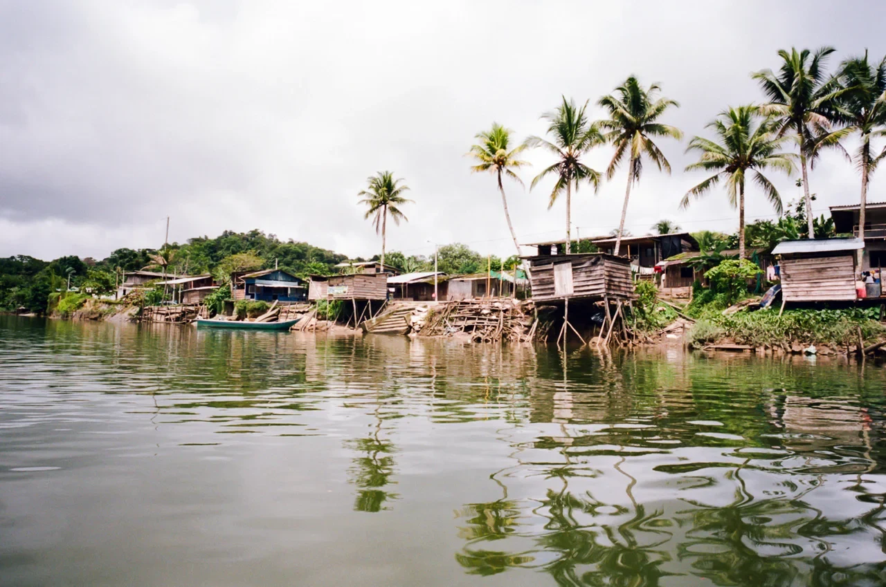 Eine Wissenschaftlerin und ein Wissenschaftler arbeiten hinter einer Glasfassade und mischen Chemikalien mit Großgeräten.