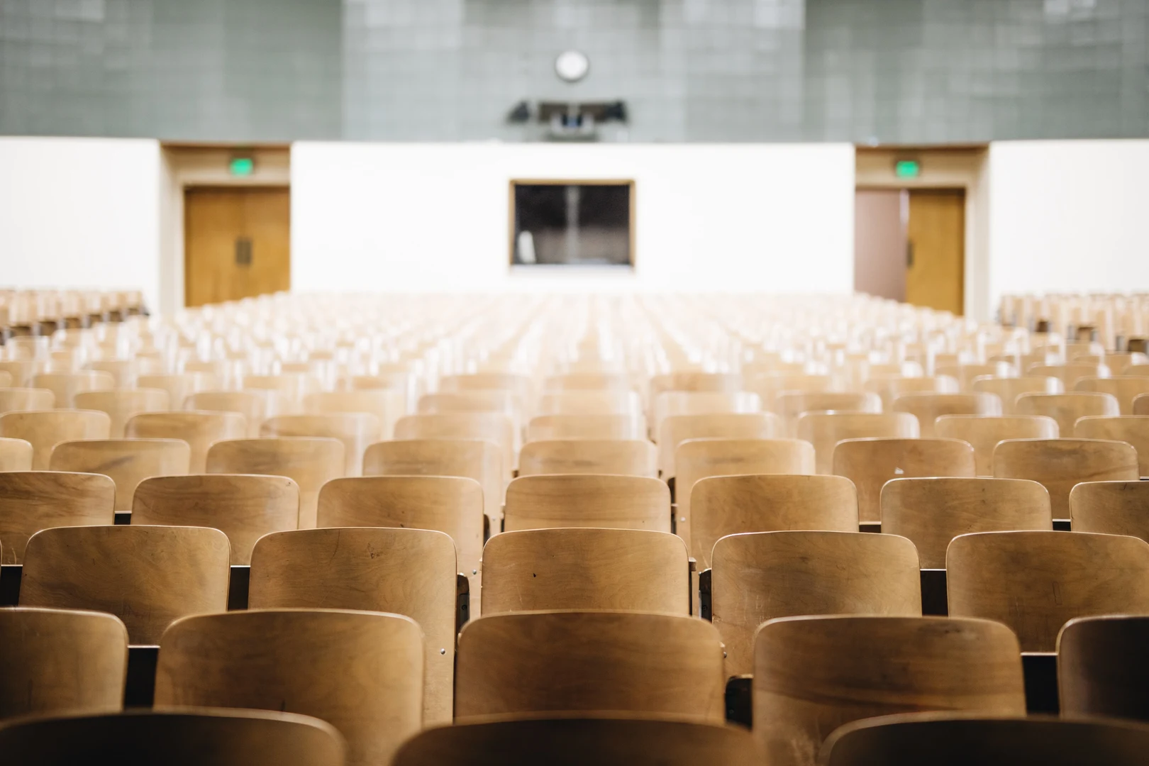 Eine Wissenschaftlerin und ein Wissenschaftler arbeiten hinter einer Glasfassade und mischen Chemikalien mit Großgeräten.